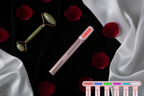 GlowVault Radiance Wand flat lay on black velvet with rose petals and skincare accessories